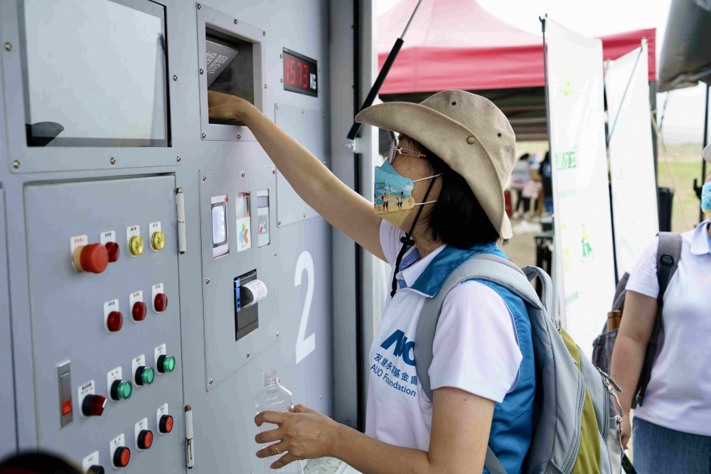 志工們將拾起的寶特瓶投入「好歸塑專車」，讓廢棄塑料空瓶可以直接粉碎、縮小體積，未來將可再製成購物袋、寶特衣、悠遊卡等生活用品